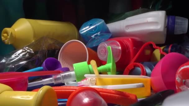 Plastic waste recycle. A pile of plastic garbage, tubes from drinks, disposable tableware, food drink and household chemicals packaging. Recycling, pollution, sustainable living. Environmental — Stock Video