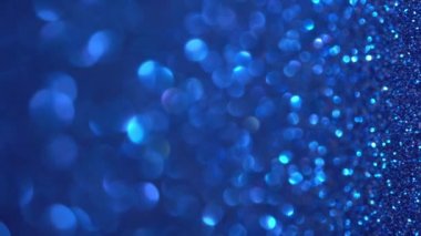 Mavi Parıltılı Dikey Arkaplan. Parlak doku, sihirli toz, tatil ışıkları, uçan parçacıklar güzel bir bokeh oluşturur. Parlak şenlikli arka plan