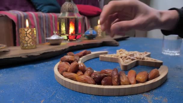 Fasting and Iftar in the month of Ramadan. A man prays and eats dates. Star and crescent — Stock Video