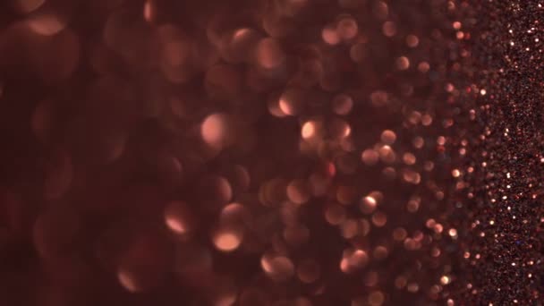 Feiertagsbeleuchtung. Abstrakter Kupfer-Glitzerhintergrund mit beweglichen und flackernden Partikeln. Magischer Staub, metallische Pailletten, glänzende Textur, fliegende Partikel bilden ein schönes Bokeh. Leuchtende Kulisse — Stockvideo