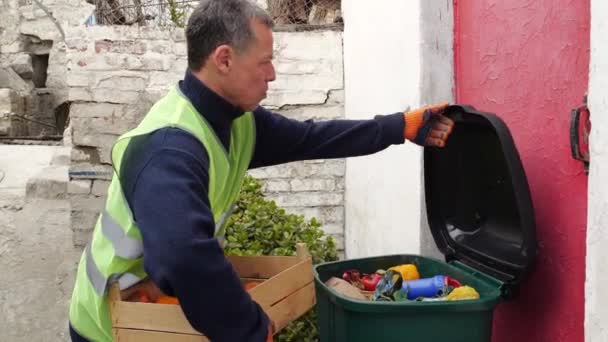 Markette Gıda israfı. Süpermarket çalışanı, satılmamış hasarlı meyveleri çöpe atıyor. — Stok video