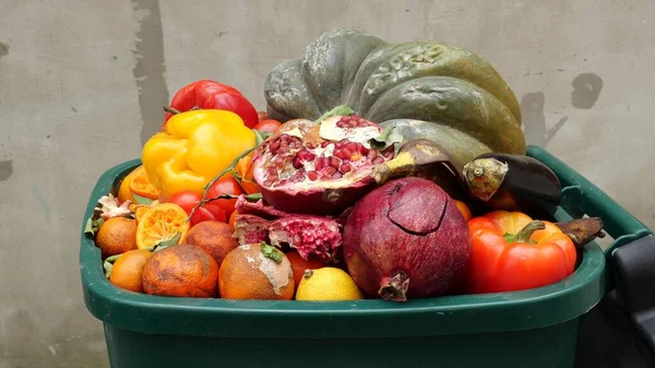 Residuos de alimentos en la tienda de comestibles. Se descartan las frutas y verduras dañadas no vendidas en envases. Los alimentos producidos se desperdician — Foto de Stock