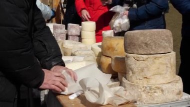 Orta yaşlı bir çiftçi çifti, yerel bir çiftçi pazarında zanaatkar peyniri satıyor. Aile şirketi.