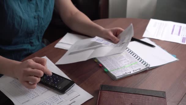 The housewife counts the expenses on the calculator. The financial crisis during the sanctions. Electricity and gas bills, loans and mortgages, invoices, debts on accounts — Stock Video