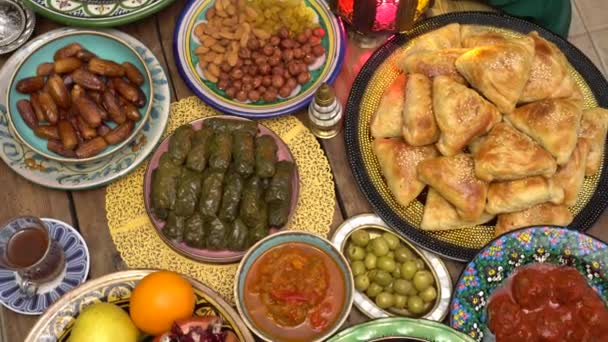 La nourriture du Ramadan. Table avec nourriture orientale, plats d'agneau, samosa, dattes et bonbons. Vue du dessus — Video