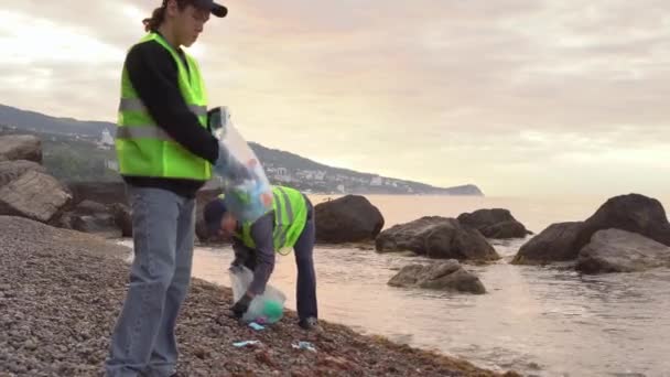 用过的面具污染了海滩和海洋。Covid-19大流行病期间和之后的塑料废物。志愿人员清理海滩和海滨 — 图库视频影像