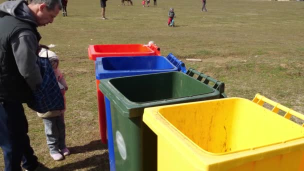 Pozbywanie się odpadów. Różne pojemniki na śmieci. Szklane plastikowe puszki z papieru recyklingu odpadów. Tata uczy córkę sortowania odpadów domowych — Wideo stockowe