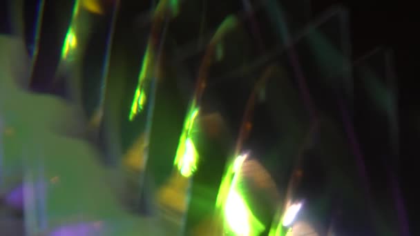 Rostos de vidro e refracções do arco-íris. Luzes desfocadas coloridas bokeh. Espumante destaca cores. Fundo holográfico abstrato — Vídeo de Stock