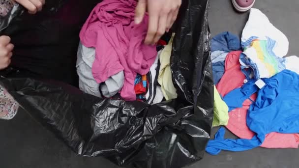 Textielafval wordt verzameld en vervolgens gesorteerd. Oude gebruikte spullen worden verzameld in een vuilniszak — Stockvideo