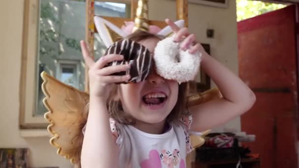 Happy Little Girl Party Unicorn Costume Applies Eyes Sweet Donuts — Stock Video