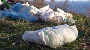 Doğada kullanılmış bebek bezi yığını. Kişisel temizlik, banyo atıkları. Tek kullanımlık bezlerin çevresel etkisi. Doğanın plastik kirliliği. Toprak, su ve hava kirliliği.