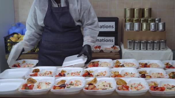 Доброволец Продовольственного Банка Донорство Еды Добровольцы Раздают Горячие Блюда Нуждающимся — стоковое видео