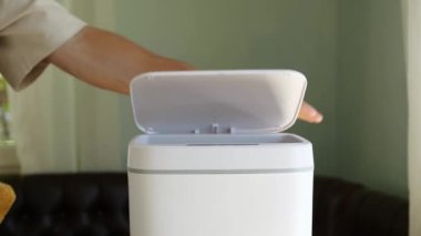 A man throws an old used dish sponge into the trash. Contactless Smart Touch Trash Can. High quality 4k footage