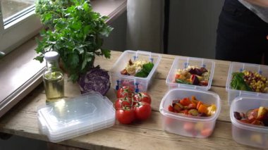 Meal prep. Homemade takeaway food in plastic containers. Woman cooks healthy office lunch portion at home. Keto diet. High quality FullHD footage