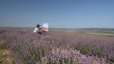 The artist paints a landscape. Oil painting in the open air. Lavender Blooming Field. High quality 4k footage