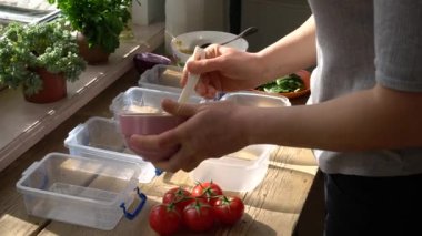 Yemek hazırlığı. Plastik konteynırlarda ev yapımı yemek. Kadınlar evde sağlıklı ofis yemekleri pişirir. Keto diyeti. Yüksek kaliteli FullHD görüntüler