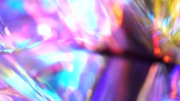 ホログラフィックな虹ピンクパープルブルー抽象的な動きのお祝いの背景 光るとグレア ガラスの結晶を通して光と光線 高品質4K映像 — ストック動画