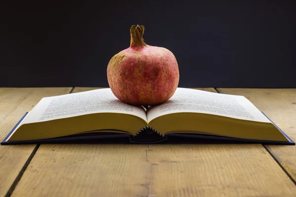 Boek met een granaatappel — Stockfoto