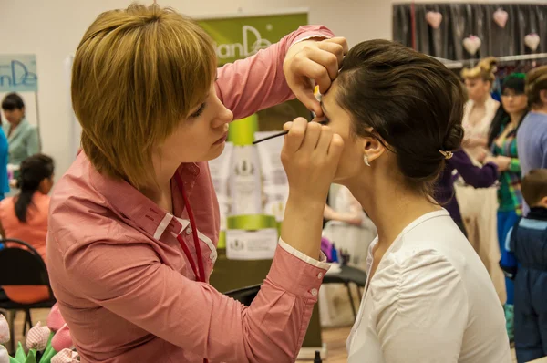 Make-up artiest brengen make-up meisje. — Stockfoto