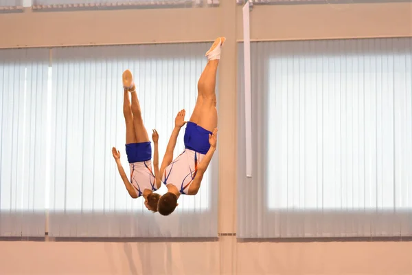 两个男孩在蹦床上同步跳跃训练 — 图库照片