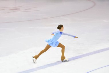 Artistik patinajcı kız buz pateni pistinde suni buz ile yuvarlanıyor. 