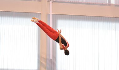 Young men are training in trampoline jumping, preparing for competitions 