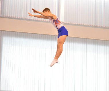 Young men are training in trampoline jumping, preparing for competitions 