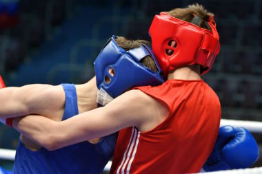 İki genç boksör bir boks ringinde yarışıyor. 