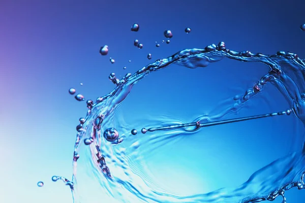 Klare Wasserflüssigkeit Spritzt Auf Blauem Hintergrund Stockbild