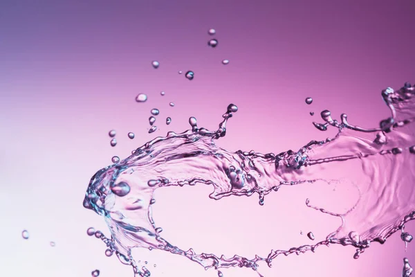 Klares Wasser Flüssigkeit Spritzer Auf Einem Lila Hintergrund Stockbild