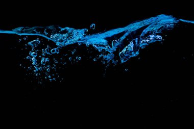 Dalgalanma ve mavi ışıkta kabarcıklar olan temiz su yüzeyi, siyah bir arka planda.