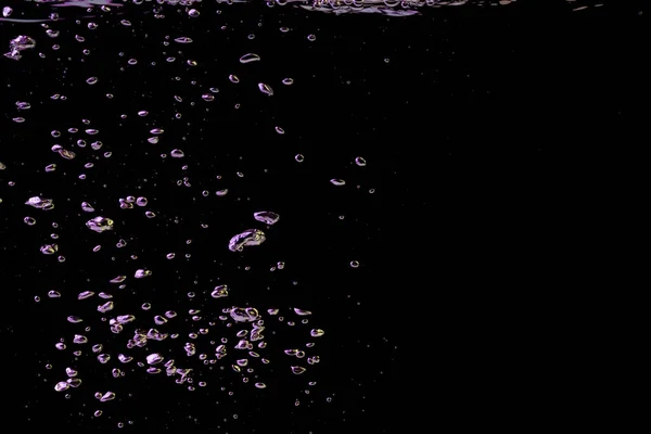 Bublina Stříkající Průhledné Čiré Vodě Tekutiny Žlutém Fialovém Světle Černém — Stock fotografie