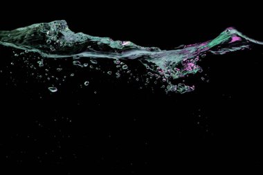 Clear water surface with ripple and bubbles in blue and purple light on a black nature background