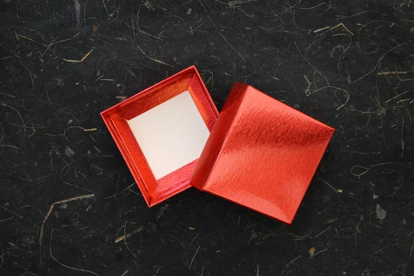 Scatola rossa su carta gelso nera — Foto Stock