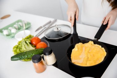 Kadın tavada omlet pişiriyor..