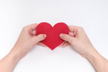 Beyaz arka plan, aşk, romantizm ve duygular karşısında kırmızı bir kalp tutan kadın elleri