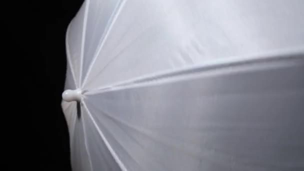 Torcendo, girando um guarda-chuva branco no escuro, escuridão — Vídeo de Stock