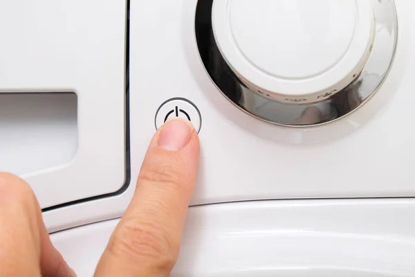 Female hand pushing start stop button of washer, washing machine cycle interraption or starting, beginning — Stock Photo, Image