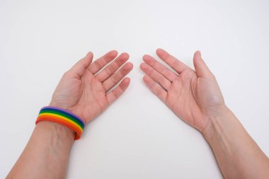 Beyaz arka planda lgbt gökkuşağı braselet giyen eller, gurur ayı konsepti.
