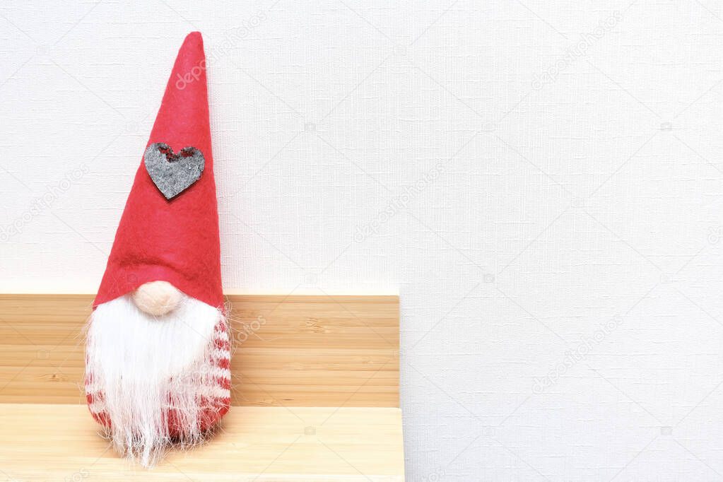 A Christmas elf, gnome, dwarf sitting on a shelf with copy space, holiday ambience atmosphere