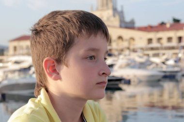 Bir çocuk bir tatil köyünün setinde oturuyor, üzgün, çünkü tüm tiyatrolar ve müzeler kapalı veya ziyaretçilere sadece QR kodu, yeşil geçiş kartı veya aşı pasaportu verilmesine izin veriliyor.