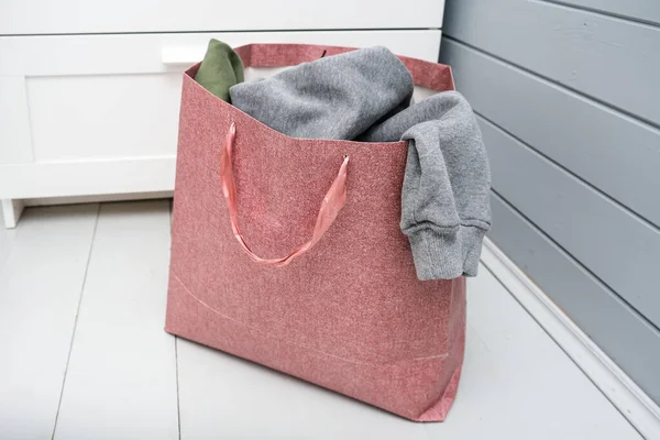 Paper bag full of old used clothes for donation and charity — Stock Photo, Image