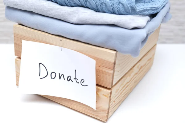 Caja de madera llena de ropa usada vieja para donación y caridad, reciclar y reutilizar ropa Fotos de stock libres de derechos