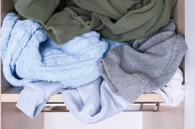 Giysiler bir gardırop rafında dağınık vaziyette.