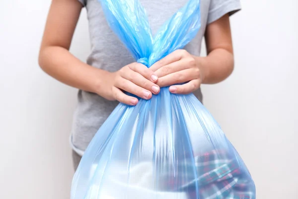 Un adolescente sosteniendo una gran bolsa de plástico af ropa para reciclar — Foto de Stock