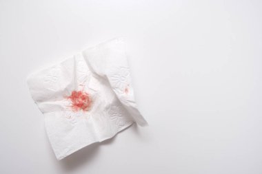 Beyaz arka planda kullanılmış tuvalet kağıdındaki kan, anal kanama ve hemoroit konsepti