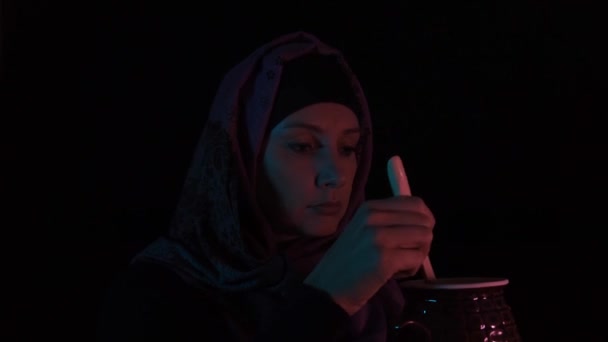 Woman witch brewing a potion and tasting it in the dark, witchcraft and magical rituals — Stock Video