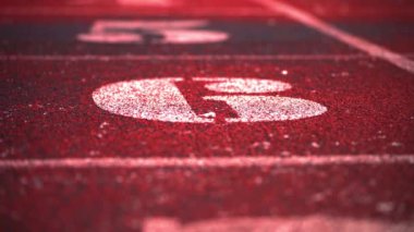 Koşu izleri. Numaralı kırmızı lastik koşu bantları. Spor arenası. Atletizm. 
