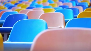 Stadyumda çok renkli sandalyeler var. Arenadaki boş plastik koltuklar. Kararlılık, Dayanıklılık, Motivasyon, Çaba