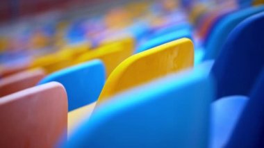 Stadyumda çok renkli sandalyeler var. Arenada boş plastik koltuklar